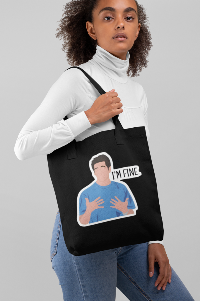 tote bag mockup of a woman with curly hair against a plain backdrop 28869 1