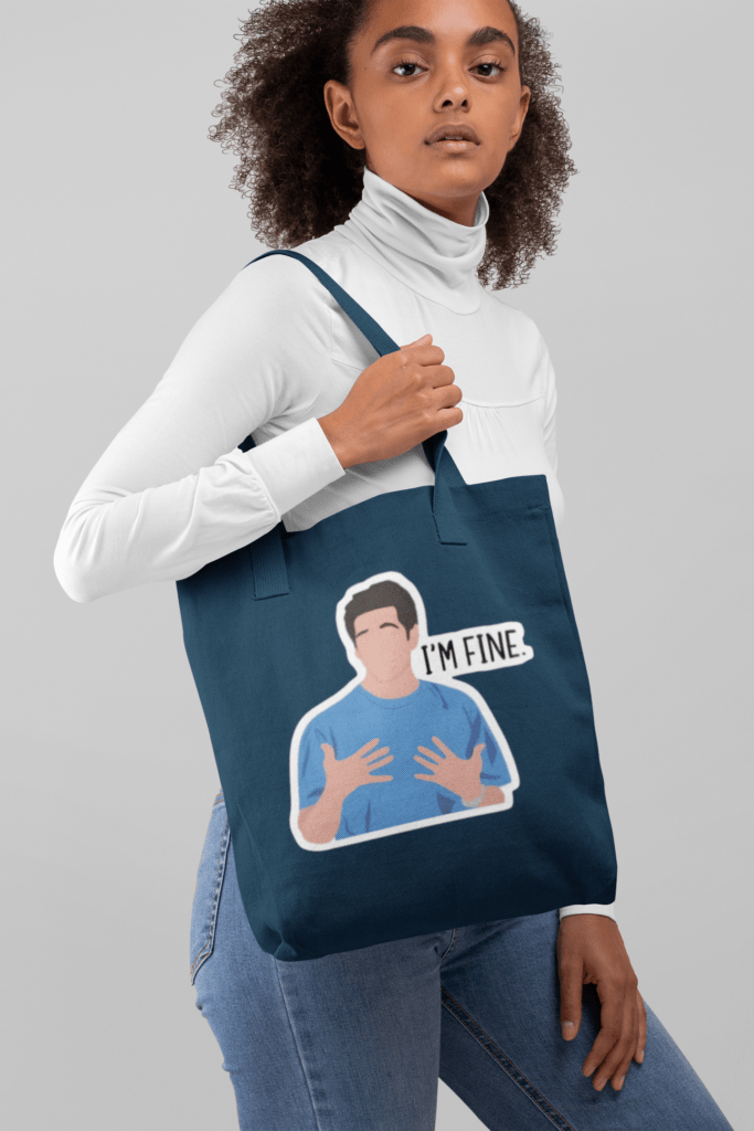 tote bag mockup of a woman with curly hair against a plain backdrop 28869